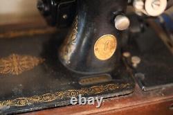 Antique Singer sewing machine with wood case and has key