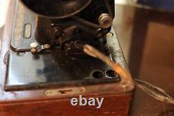 Antique Singer sewing machine with wood case and has key