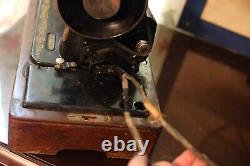 Antique Singer sewing machine with wood case and has key