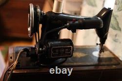 Antique Singer sewing machine with wood case and has key