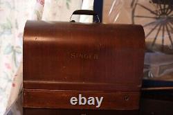 Antique Singer sewing machine with wood case and has key