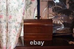 Antique Singer sewing machine with wood case and has key