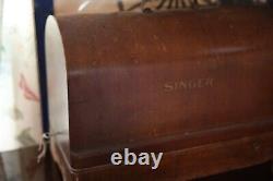 Antique Singer sewing machine with wood case and has key