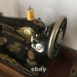 Machine à coudre Singer 1920 avec ailes décoratives, accessoires motorisés et boîtier en bois courbé