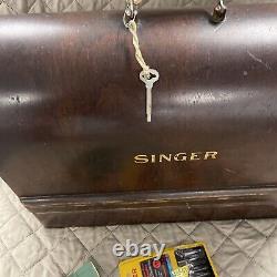 Machine à coudre Singer antique avec clé pour meuble en bon état de fonctionnement et manuel.