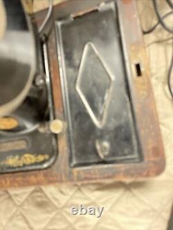 Machine à coudre Singer antique avec clé pour meuble en bon état de fonctionnement et manuel.