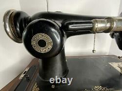 Machine à coudre Singer de collection en noir et or avec levier au genou et boîte de rangement en bois verrouillable.