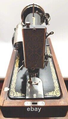 Machine à coudre Singer modèle 99 de 1928 avec boîtier en bois courbé et contrôle à genouillère vintage.