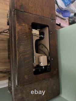 Machine à coudre à pédale Singer antique dans un meuble, vintage du début des années 1900