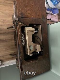 Machine à coudre à pédale Singer antique dans un meuble, vintage du début des années 1900