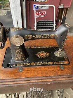 Machine à coudre à pédale Singer antique de 1919 dans un meuble en bois modèle Red Eye 66.