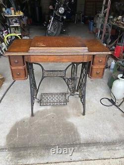 Machine à coudre à pédale Singer antique de 1919 dans un meuble en bois modèle Red Eye 66.