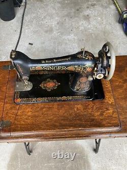 Machine à coudre à pédale Singer antique de 1919 dans un meuble en bois modèle Red Eye 66.