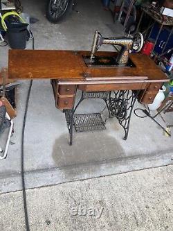 Machine à coudre à pédale Singer antique de 1919 dans un meuble en bois modèle Red Eye 66.