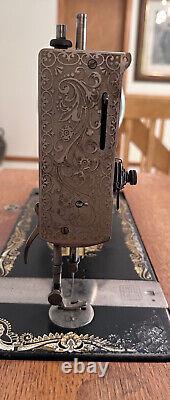 Machine à coudre à pédales Singer antique, modèle 27 avec cabinet en chêne et décorations Spinx, 1901.