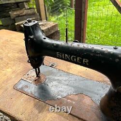 Machine à coudre industrielle Singer antique, modèle No. 31-15, avec table en bois et pédale.