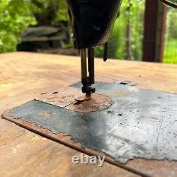 Machine à coudre industrielle Singer antique, modèle No. 31-15, avec table en bois et pédale.